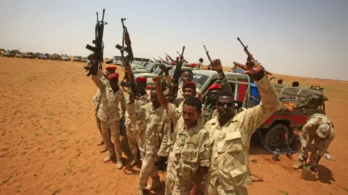 مقاتلون من قوات الدعم السريع يحملون أسلحة في منطقة صحراوية، مع ظهور عربات عسكرية خلفهم، في سياق الصراع في المثلث الحدودي.