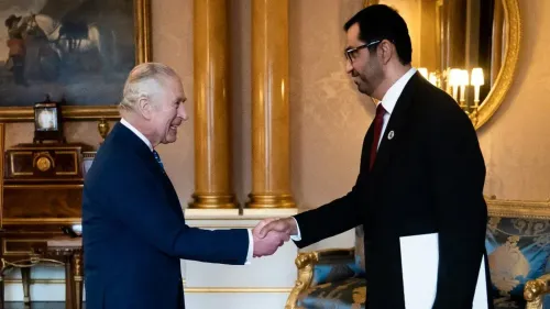 لقاء بين مسؤول إماراتي وملك المملكة المتحدة، حيث يتبادلان التحية في إطار مناقشات حول العلاقات الثنائية والتوترات السياسية.