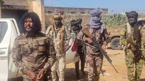 مسلحون سودانيون يرتدون زيّاً عسكرياً ويقفون بجانب مركبات في منطقة صحراوية، مرتبطون بتقارير عن دور الإمارات في دعم قوات الدعم السريع في السودان.