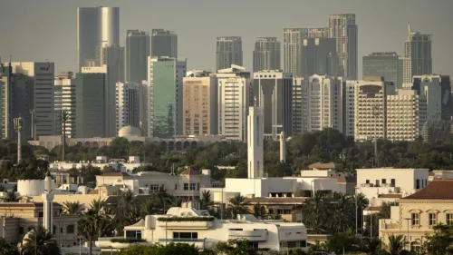 صورة لمدينة أبوظبي تظهر مزيجًا من المباني الحديثة والقديمة، تعكس التباين بين التطور العمراني والتراث الثقافي.