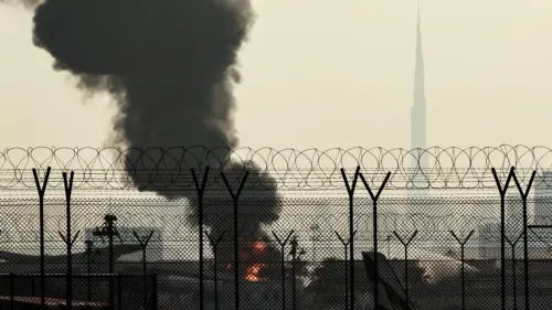 تصاعد الدخان من موقع استهداف مصفاة نفطية في إيران، مع ظهور برج خليفة في الخلفية، مما يعكس التوترات العسكرية بين الإمارات وإيران.