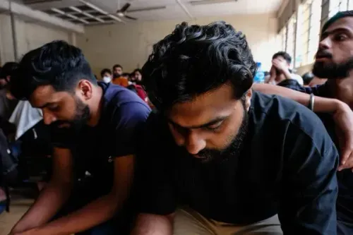 مجموعة من الرجال يجلسون في غرفة مغلقة، يظهر عليهم القلق والتوتر، في سياق حملة أمنية ضد الهجرة غير النظامية في أوغندا.