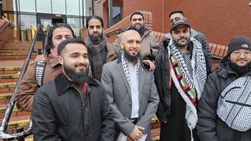 مجموعة من الرجال يقفون معًا خارج مبنى، بعضهم يرتدي الأوشحة الفلسطينية، في سياق دعم ناشط فلسطيني تمت تبرئته في ليستر.