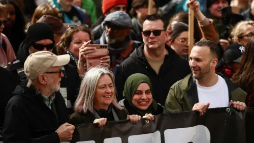 تجمع حشد من المتظاهرين في فعالية سياسية، حيث يظهر بعضهم يحمل لافتات. تعكس الأجواء دعمًا للقضايا الاجتماعية والسياسية.