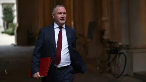 وزير المجتمعات المحلية البريطاني ستيف ريد يسير في ممر، محذرًا المجالس من مقاضاتها بسبب مقاطعة الشركات الإسرائيلية.