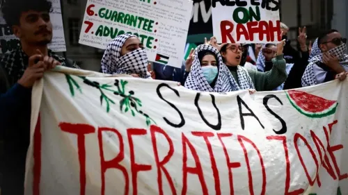 محتجون يحملون لافتة مكتوب عليها "SOAS منطقة محررة" خلال مظاهرة لدعم القضية الفلسطينية، مع شعارات أخرى تعبر عن التضامن.