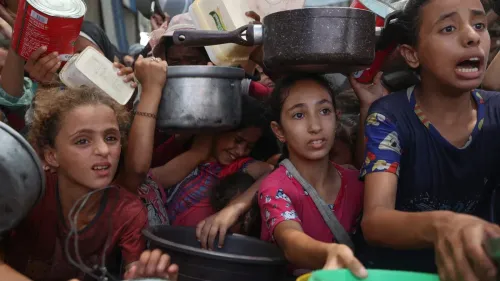 نساء وأطفال فلسطينيون يتجمعون في حالة من الفوضى للحصول على المساعدات الإنسانية في غزة، وسط ظروف إنسانية صعبة.