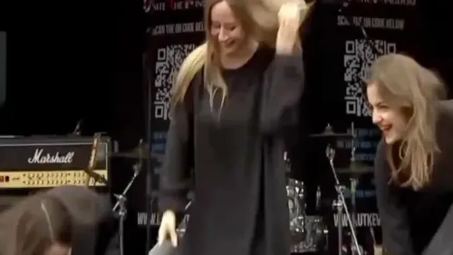 نساء يرتدين النقاب الأسود على المنصة، يخلعنه ويرمونه، بينما يتعالى صياح الحشد في مسيرة "Unite the Kingdom" في لندن.