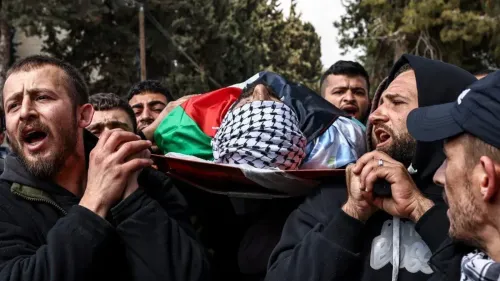 محتجون يحملون جثمان فلسطيني مغطى بعلم فلسطين، يعبرون عن حزنهم في جنازة، في سياق التوترات المتزايدة في الضفة الغربية.