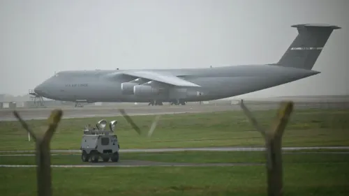 هبوط طائرة شحن C-5 Galaxy التابعة لسلاح الجو الأمريكي في قاعدة فيرفورد، مع وجود مركبة عسكرية على المدرج.