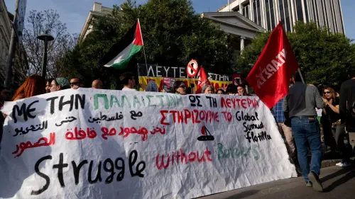 تجمع حشود من المتظاهرين في الشارع، يحملون لافتات تدعم "Global Sumud Flotilla" وتطالب بالحرية لفلسطين، مع العلم الفلسطيني في الخلفية.