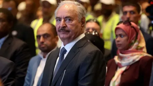 حفتر، القائد العسكري الليبي، يظهر في مؤتمر مع مسؤولين، وسط مزاعم بانتهاكات حقوق الإنسان وتوترات سياسية في ليبيا.