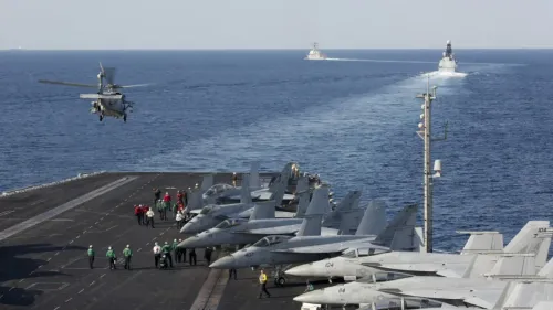 حاملة الطائرات الأمريكية أبراهام لينكولن في البحر، مع طائرات مقاتلة على سطحها، وتواجد طاقم عسكري، في سياق تعزيز الوجود العسكري بالشرق الأوسط.
