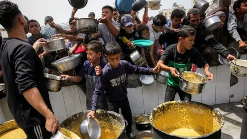 أطفال وراشدون في غزة يتجمعون للحصول على الطعام من مطبخ ميداني، في ظل نقص حاد في الإمدادات الغذائية بسبب الأوضاع الراهنة.