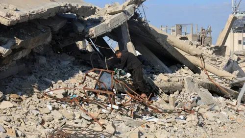 رجل يعمل على إزالة الأنقاض في موقع دمار كبير في غزة، حيث تظهر آثار الصراع المستمر والدمار الناتج عنه.