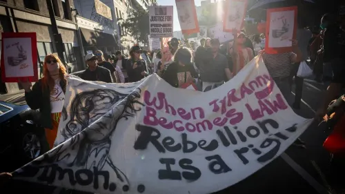 مظاهرة في مينيابوليس ضد إدارة الهجرة والجمارك، حيث يحمل المحتجون لافتات تدعو للعدالة ويعبرون عن استيائهم من العنف ضد المدنيين.