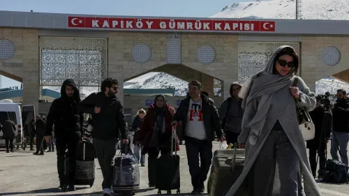 المسافرون يتجهون نحو بوابة كابيكوي الحدودية التركية، مع حقائبهم، في مشهد يعكس الحركة النشطة على الحدود.