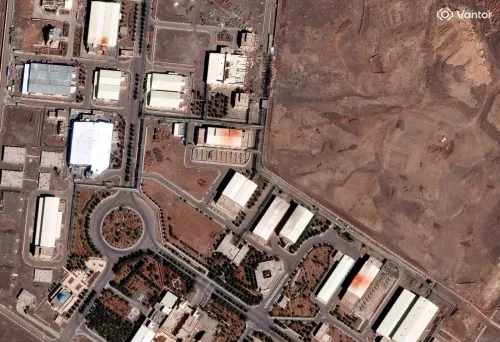 صورة فضائية لموقع نووي إيراني يظهر فيه مجموعة من المباني والمنشآت المحاطة بأراضٍ قاحلة، تعكس التوترات المتعلقة بالبرنامج النووي الإيراني.