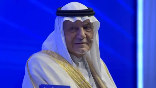 الأمير تركي الفيصل يتحدث خلال مؤتمر، مع خلفية زرقاء، معبراً عن موقف السعودية من التوترات الإقليمية مع إيران والمخططات الإسرائيلية.