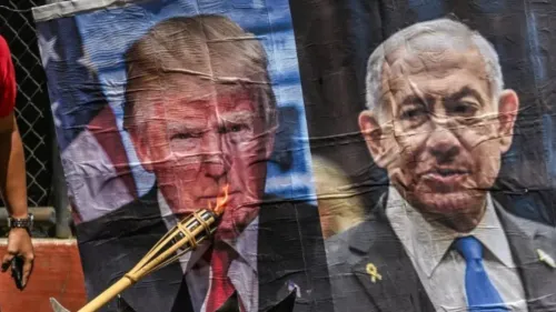 شخص يحمل شعلة مشتعلة بالقرب من لافتة تحمل صورتي ترامب ونتنياهو، تعبيرًا عن الاحتجاج على السياسات الأمريكية والإسرائيلية.