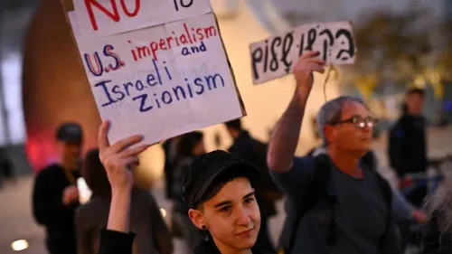 متظاهر يحمل لافتة مكتوب عليها "لا للإمبريالية الأمريكية والصهيونية الإسرائيلية" في احتجاج ضد الحرب في القدس.