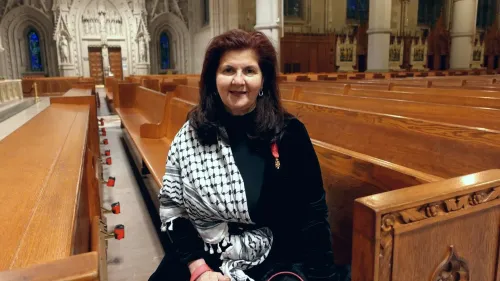امرأة تجلس في كاتدرائية القلب الأقدس، ترتدي وشاحًا يحمل الألوان الفلسطينية، تعبر عن حزنها بعد وفاة البابا فرنسيس.