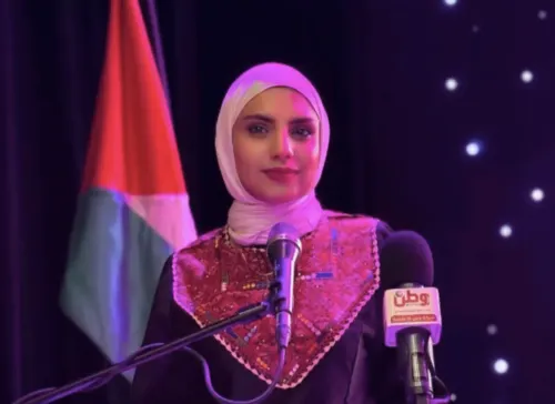 صحفية ترتدي زياً تقليدياً فلسطينيًا، تقف أمام ميكروفون مع العلم الفلسطيني في الخلفية، تعكس واقع الاعتقالات في الضفة الغربية.