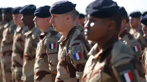 جنود من القوات الفرنسية يرتدون زيهم العسكري في تشكيل، يظهرون في قاعدة عسكرية في العراق وسط تصاعد التوترات الإقليمية.