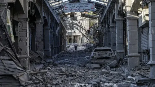 شارع مدمر في لبنان بعد الغارات الإسرائيلية، يظهر حطام المباني والمركبات وسط الغبار، مما يعكس آثار النزاع المستمر في المنطقة.