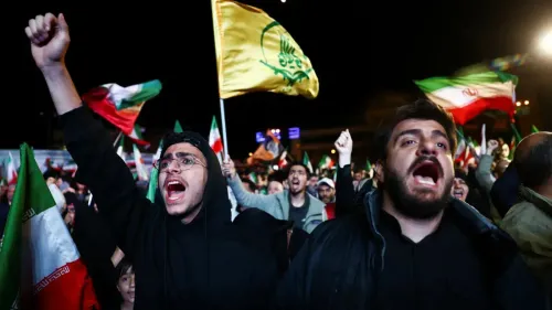 محتجون إيرانيون يرفعون الأعلام ويهتفون خلال تجمع حاشد، تعبيرًا عن دعمهم لخطط الحكومة الإيرانية في ظل التوترات مع الولايات المتحدة.