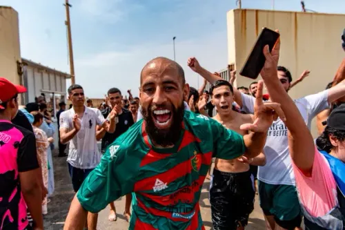 مهاجرون شباب يحتفلون بحماس بعد عبورهم الحدود إلى سبتة، الجيب الإسباني في شمال أفريقيا، وسط موجة هجرة كبيرة من المغرب.