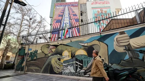 جدارية في طهران تظهر رموزًا وطنية إيرانية وأعلام الولايات المتحدة وإسرائيل، تعكس التوترات السياسية الحالية.