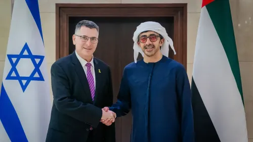 وزير الخارجية الإسرائيلي يتصافح مع نظيره الإماراتي، مع العلم الإسرائيلي والإماراتي في الخلفية، في إطار جهود التطبيع بين الدول.