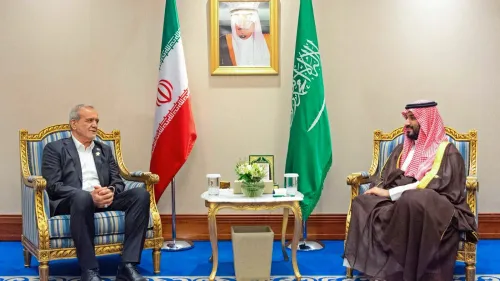 اجتماع بين مسؤول إيراني وولي العهد السعودي، مع العلميات الإيرانية والسعودية خلفهم، يعكس التوترات الإقليمية والتغيرات السياسية.