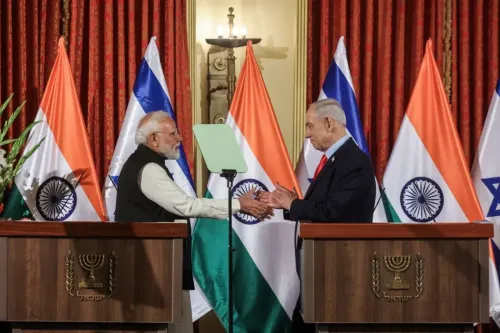 رئيس الوزراء الهندي ناريندرا مودي يتصافح مع رئيس الوزراء الإسرائيلي بنيامين نتنياهو خلال مؤتمر صحفي، مع العلمين الهندي والإسرائيلي خلفهما.