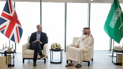 الأمير ويليام يجلس مع ولي العهد السعودي محمد بن سلمان، مع العلم البريطاني والعلم السعودي خلفهما، في إطار زيارة دبلوماسية لتعزيز العلاقات.