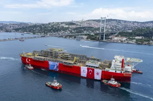 سفينة الغاز التركية في مضيق البوسفور، محاطة بزوارق صغيرة، مع خلفية للمدينة والجبال، تعكس جهود تركيا في تأمين إمدادات الطاقة.