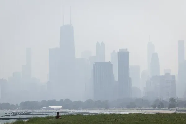 دخان كثيف يغطي أفق مدينة شicago، مما يؤثر على جودة الهواء ويزيد من المخاطر الصحية، خاصة للمجموعات الحساسة.