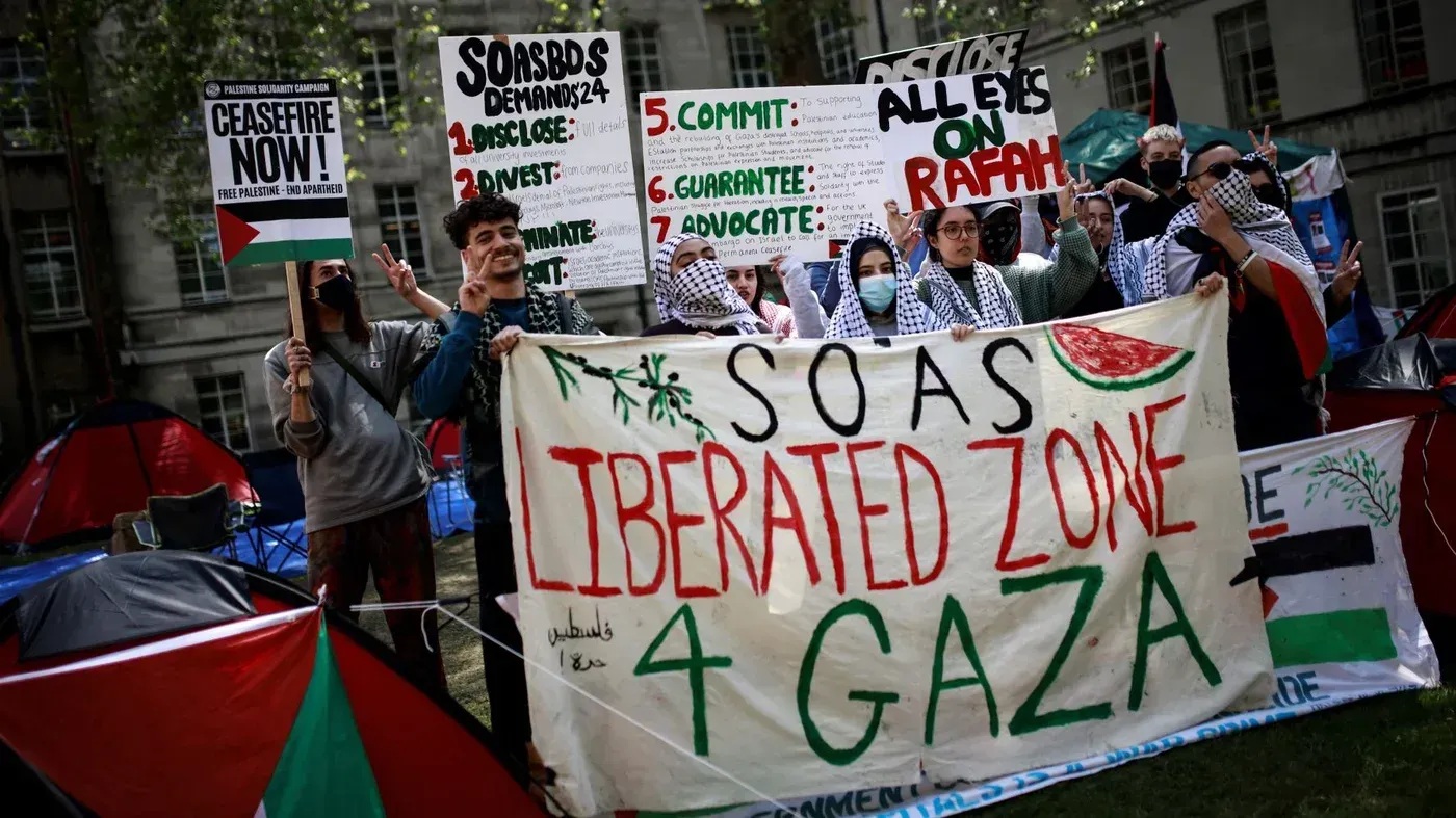 محتجون أمام جامعة سواس يحملون لافتات تدعو إلى وقف إطلاق النار ودعم فلسطين، مع لافتة كبيرة مكتوب عليها "منطقة محررة 4 غزة".