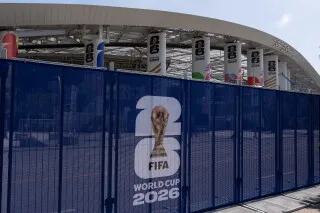 حواجز أمنية أمام ملعب كأس العالم 2026، مع شعار البطولة، تعكس إجراءات التفتيش المشددة للرياضيين والمشاركين.