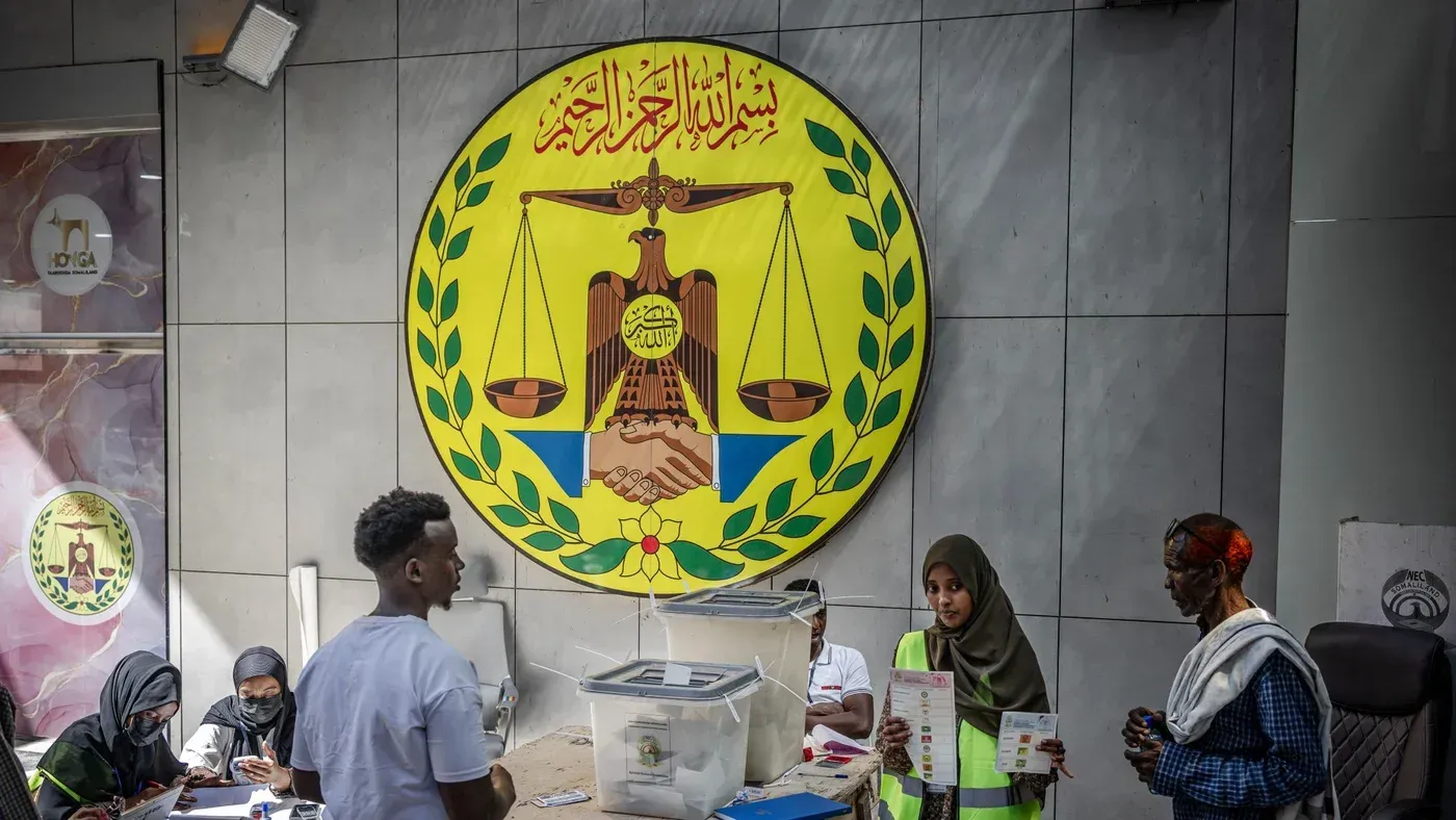 مواطنون في أرض الصومال يتفاعلون أمام مركز انتخابي، مع شعار يمثل العدالة، وسط أجواء من التوتر السياسي بعد اعتراف إسرائيل بالإقليم.