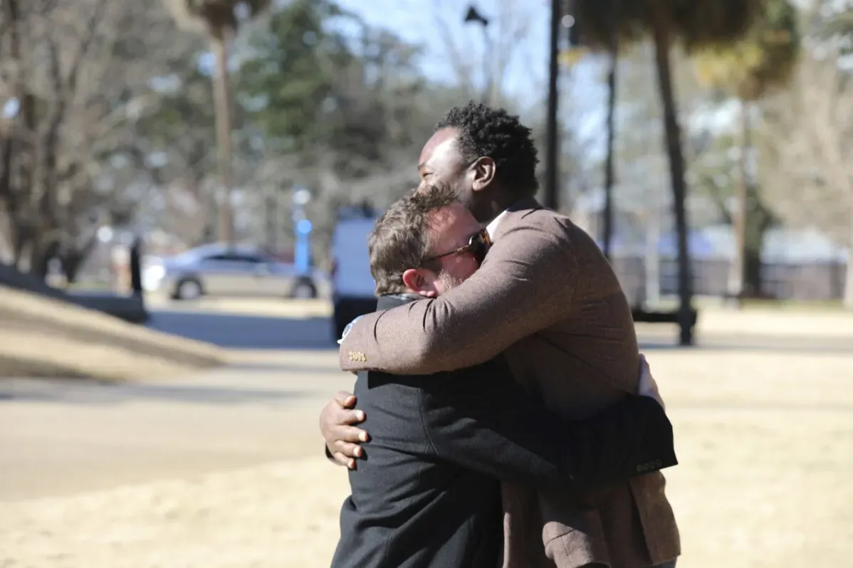 لحظات عاطفية بين نائبين، أحدهما أبيض والآخر أسود، يتعانقان في موقع تمثال روبرت سمولز المقترح في كارولينا الجنوبية.