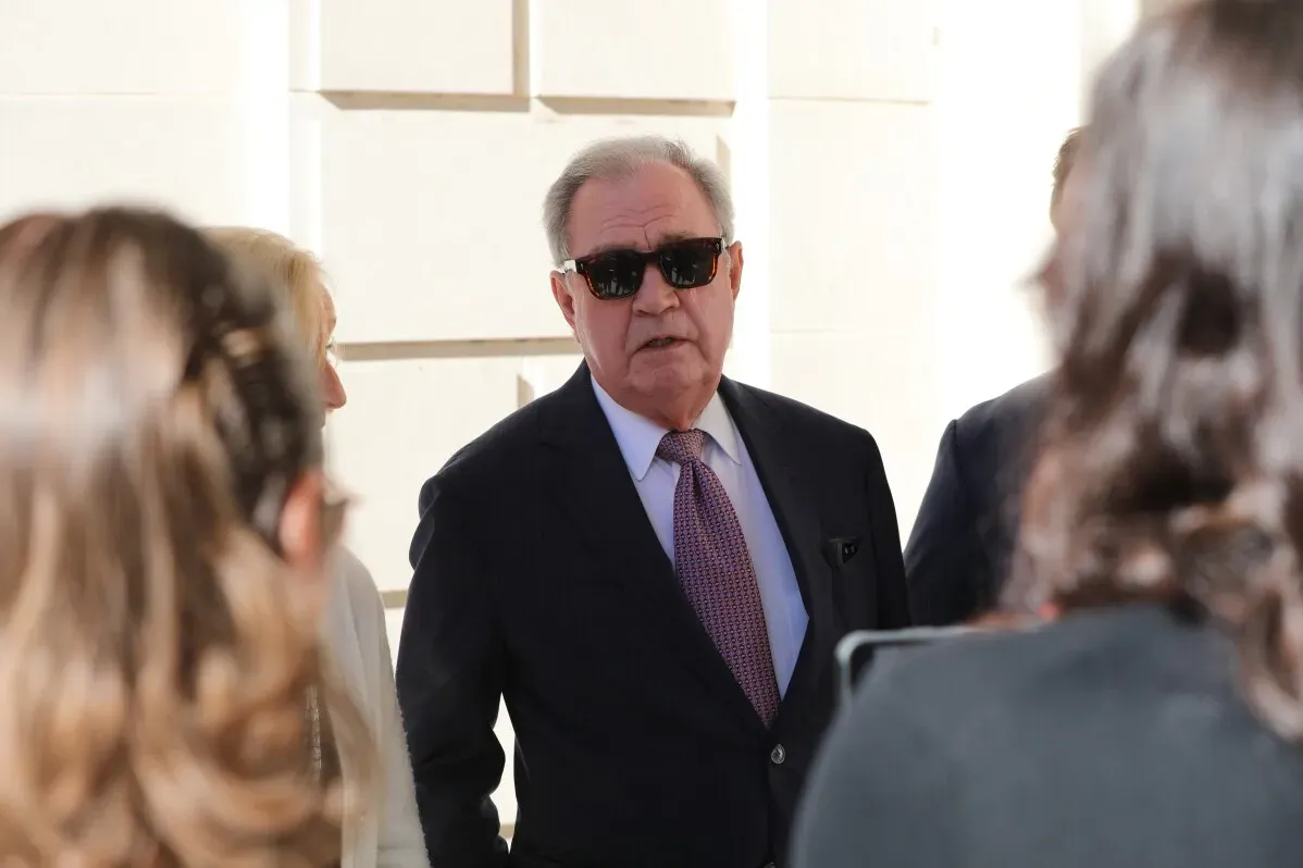 مشرع يرتدي نظارات شمسية يتحدث مع مجموعة من الأشخاص خارج مبنى المحكمة العليا في ساوث كارولينا، وسط مناقشات حول زيادة الرواتب.