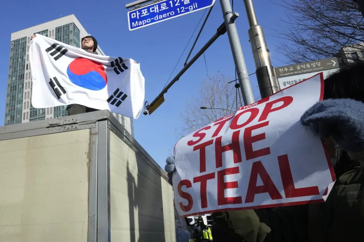 محتجون في سيئول يحملون علم كوريا الجنوبية ولافتة تطالب بوقف السرقة، تعبيرًا عن دعمهم للرئيس المعزول يون سوك يول وسط توترات سياسية.