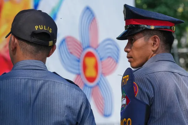 شرطيان فلبينيان يقفان أمام شعار رابطة دول جنوب شرق آسيا (ASEAN) خلال اجتماع دبلوماسي في مانيلا لمناقشة الأزمات الإقليمية والشرق أوسطية.