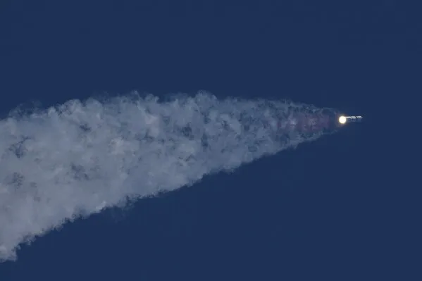 صاروخ Starship من SpaceX ينطلق نحو السماء، محملاً بأقمار Starlink، مع آثار دخان كثيف خلفه، في اختبار تاريخي للرحلات الفضائية.