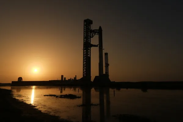 مركبة Starship العملاقة لشركة SpaceX على منصة الإطلاق في تكساس عند غروب الشمس استعداداً لرحلة اختبارية تحمل أقمار Starlink الصناعية.