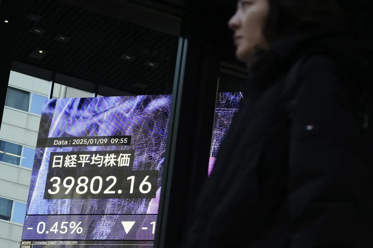 سيدة واقفة أمام شاشة تعرض مؤشر نيكاي 225، حيث يظهر الرقم 39,802.16 مع انخفاض بنسبة 0.45%.