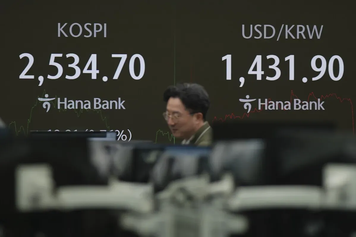 زيادة مؤشر KOSPI إلى 2,534.70 في بورصة كوريا الجنوبية، مع تواجد موظف في البنك يتابع الأسعار.