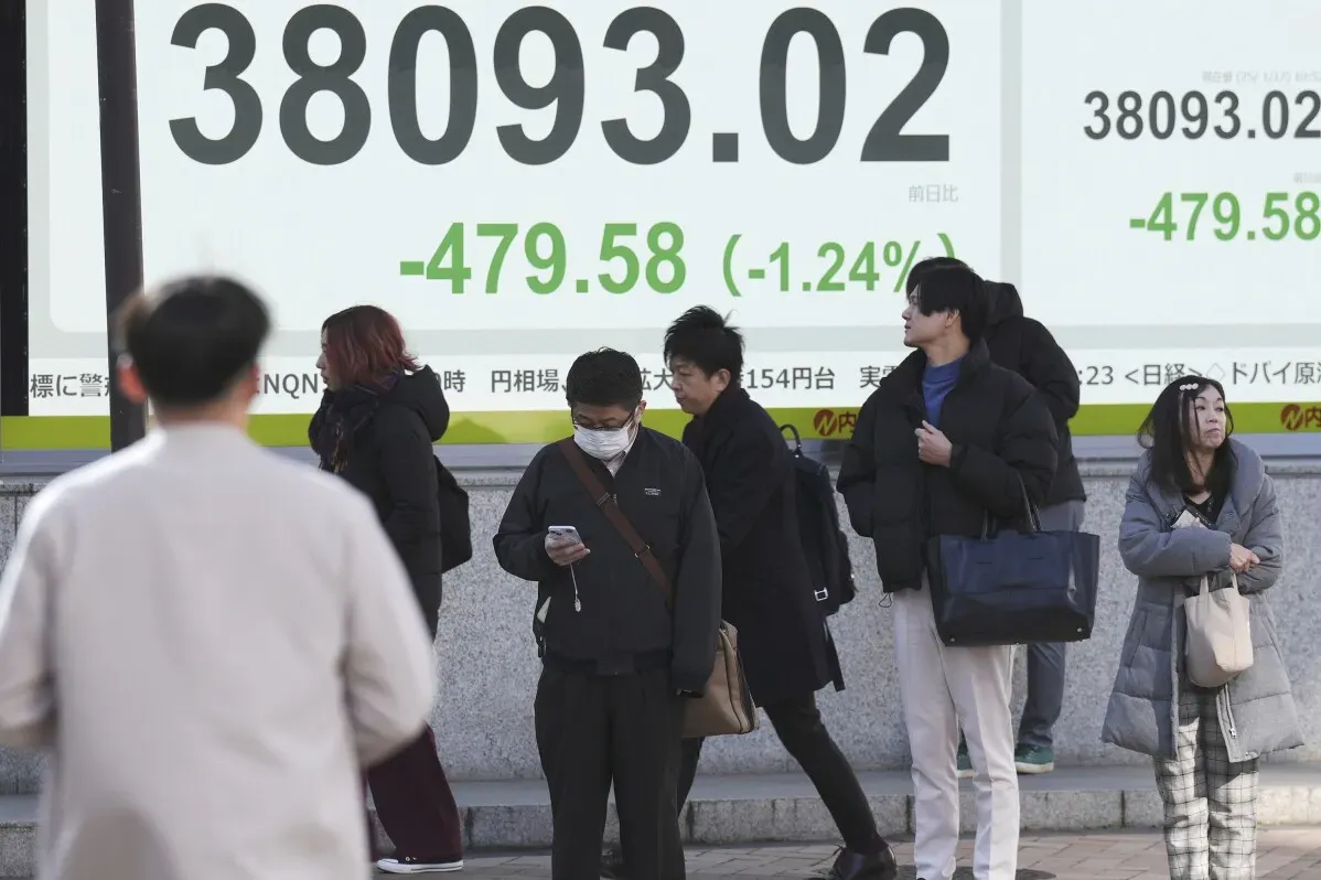 تظهر مجموعة من الأشخاص في طوكيو أمام شاشة تعرض انخفاض مؤشر نيكاي 225 بنسبة 1.24%، مما يعكس تراجع الأسواق الآسيوية.